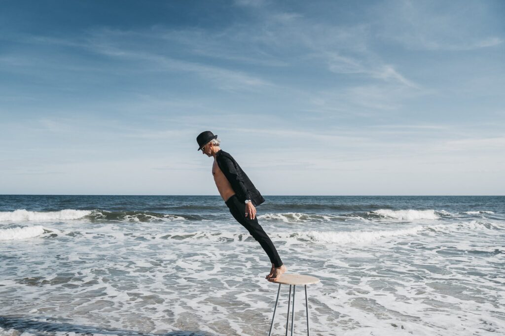 man standing on stool at seaside